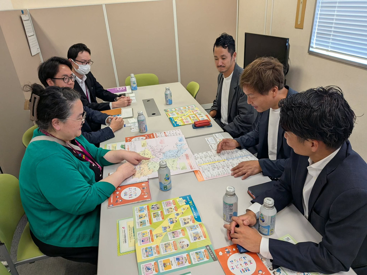 社協 会議室で子ども食堂マップを前に説明を受けるガヤ経理事メンバーと社協職員